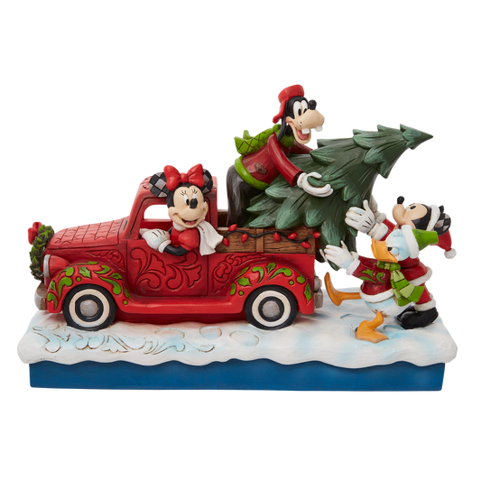 Loading a red pick up truck with a freshly picked Christmas tree, Minnie and Mickey Mouse pair up with Donald Duck and Goofy for a wonderful winter spent with friends in this Jim Shore design.